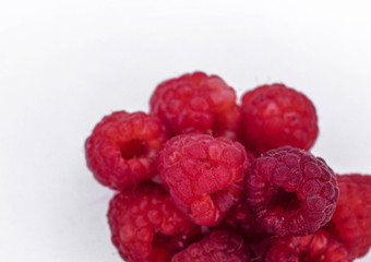 Heap of ripe raspberries on white