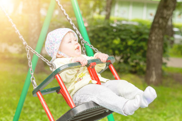 The baby is swinging on the swing