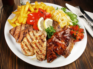 Grillteller mit Pommes Frites und Gemüse