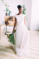 Beautiful african american bride with tropical bouquet in the studio