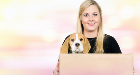 Frau hält ein Kiste mit Hund.
