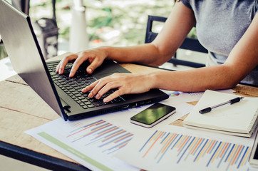 business documents on office table with laptop computer and graph financial diagram and Business people working at office