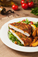 Chicken schnitzel, served with roasted potatoes and salad.