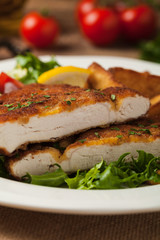 Chicken schnitzel, served with roasted potatoes and salad.