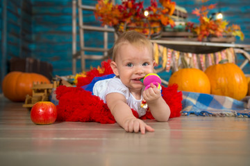 Fototapeta na wymiar Happy one year old baby girl in autumn interior