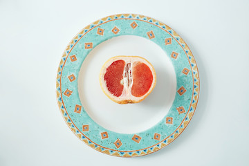Half of grapefruit on plate. From above. Healthy fitness food.