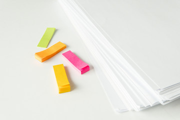 blank papers and bookmark color on white table,blank stack documents and bookmark paper on office desk.