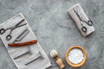 Accessories for shaving. Shaving brush, razor, foam, sciccors on grey stone table background top view copyspace