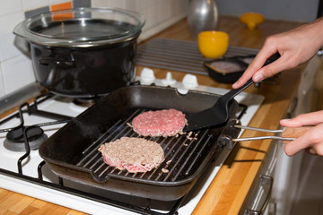 Preparing a batch of ground beef patties on grill