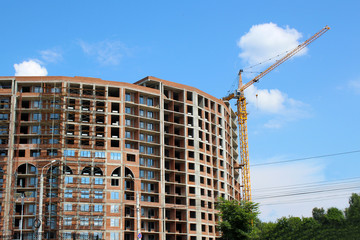 the construction crane and the building against the blue sky