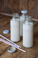 Sour-dairy drink or yoghurt in bottle that come from the kefir grains and milk on wooden background. Photographed with natural light