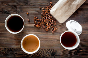 Coffee take away. Coffee cups with covers and coffee beans on wooden table backound top view