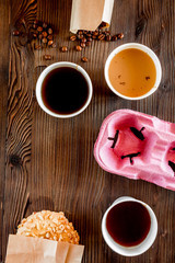Coffee take out. Coffee cups with covers, coffee beans and cookies on wooden table backound top view copyspace