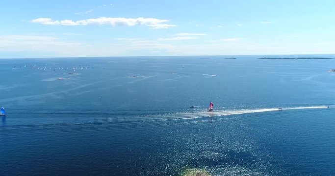 Speedboats on baltic sea, Cinema 4k aerial view of motorboats driving by sailboats, out on the turquoise sea, on hango regatta, summer day, in the finnish archipelago of Hanko, Finland