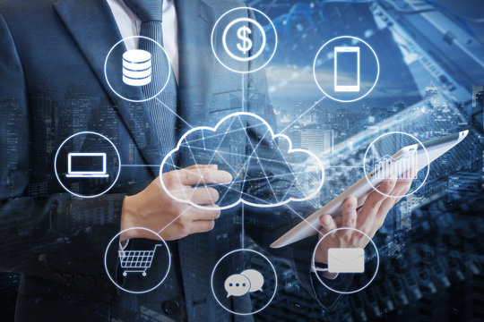 Double exposure of professional businessman connecting cloud technology network and devices on hand with tablet and cityscape & data center background in technology, communication and business concept
