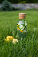 A glass decanter with a summer refreshing lemonade made of lemons and cucumber with mint added on a...