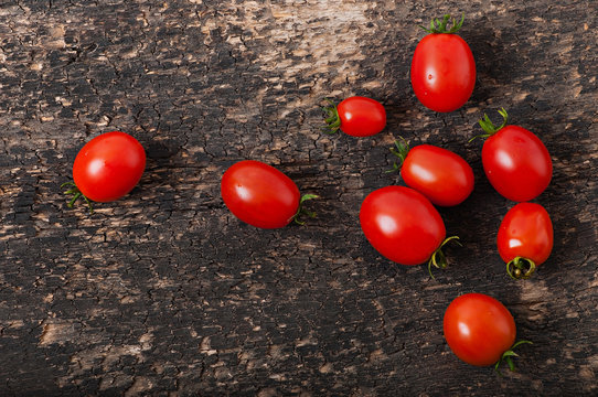 Cherry tomatoes on an old wooden background, top view.