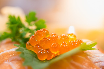 Close up of raw salmon roe / eggs is known as ikura on raw salmon sashimi - Japanese tradition food.