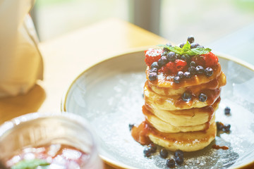 food background of stacked pancakes with sugar souse in sunny cafe at morning