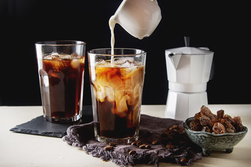 Iced coffee with milk. Summer drink. Dark background.