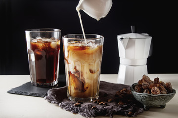 Iced coffee with milk. Summer drink. Dark background.