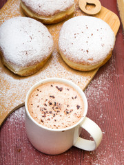 Classic donuts with powdered sugar, on wooden background
