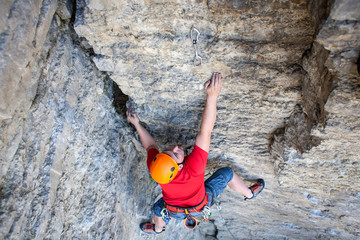 Climber in a helmet climbs up.