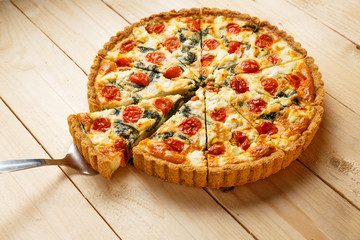 Vegetarian homemade pie, Quiche with tomatoes, spinach and feta cheese.