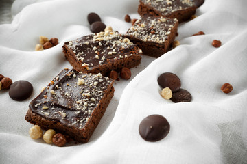 Many pieces of brownie with nuts on white background