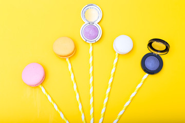Eye shadow and macaroons on a yellow background. flat lay