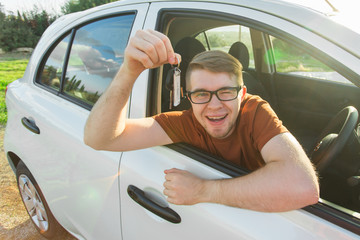 Naklejka premium Happy man showing the key of his new car