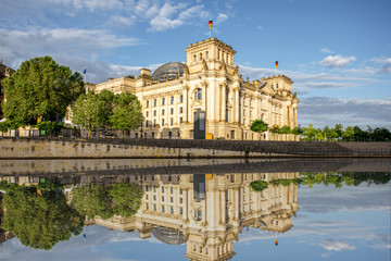 Morning cityscape view on the famous Reichstag building with beautiful reflection in the water in Berlin city