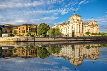 Morning cityscape view on the famous Reichstag building with beautiful reflection in the water in...