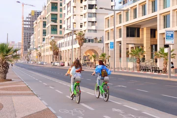 Zelfklevend Fotobehang TEL AVIV, ISRAEL- APRIL, 2017: Herbert Samuel st. bike track and walking area for pedestrians in the center of Tel Aviv. Girls ride bicycles on holiday © Stanislav Samoylik