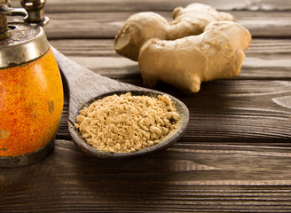Spice ginger powder,vintage handmill, ginger root  on wooden background.