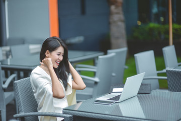 Young pretty business woman with laptop in the office, smiling pretty young business woman in glasses sitting on workplace. Selective focus