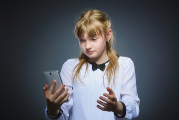 astonished cute girl with cell phone. isolated on gray