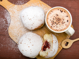 Classic donuts with powdered sugar, on wooden background