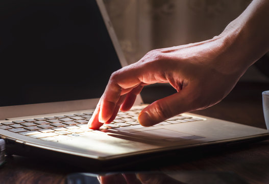 Human hand on laptop keyboard