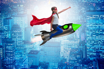 Fototapeta na wymiar Little girl flying rocket in superhero concept