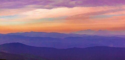 Fototapeta na wymiar Fairytale panorama of mountain ranges in the twilight and clouds, pastel colors