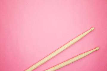 pair of wooden drumsticks on pink background
