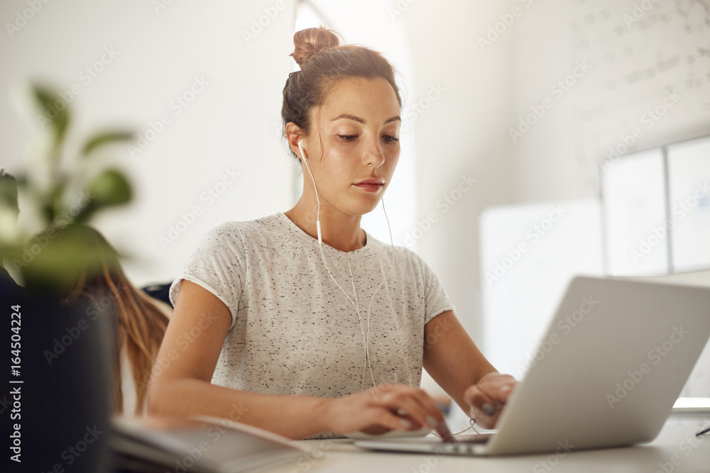 Poster young music producer using a laptop to compose an upbeat hit. freelance editor browsing through tons