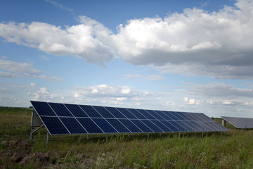 Fototapeta premium Solar energy panels in the field. View on a equipment on a solar energy power station.