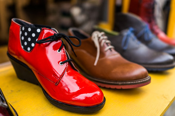 Macro closeup of vintage shoe display at store with bright red vibrant heel