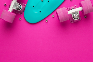 plastic mini cruiser board disassembled on deep pink with background copy space