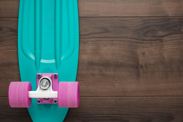 plastic mini cruiser board on wooden background with copy space