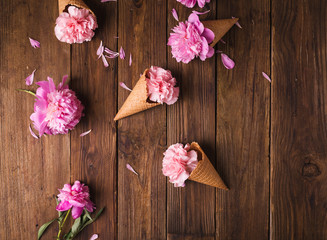 Flowers in a waffle cone. Pink carnations. Flowers on a wooden  background. Copyspace. Flower photo concept