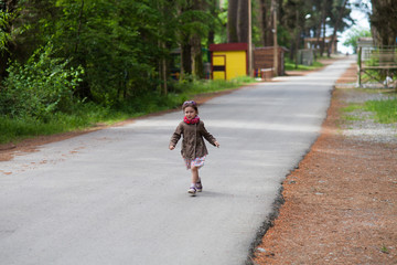 girl in a coat runs on an empty road