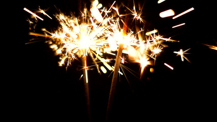 Fototapeta premium Burning Sparklers in blurred motion. Christmas New Year and Independence Day celebration lights.